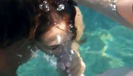 Slutty naked whore is sucking on this massive boner right under water