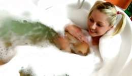 Cheery blonde is in a washroom tub washing her seductive body shaving pussy